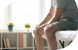 Person with knee pain sitting on an examination table – common symptom of a meniscus tear